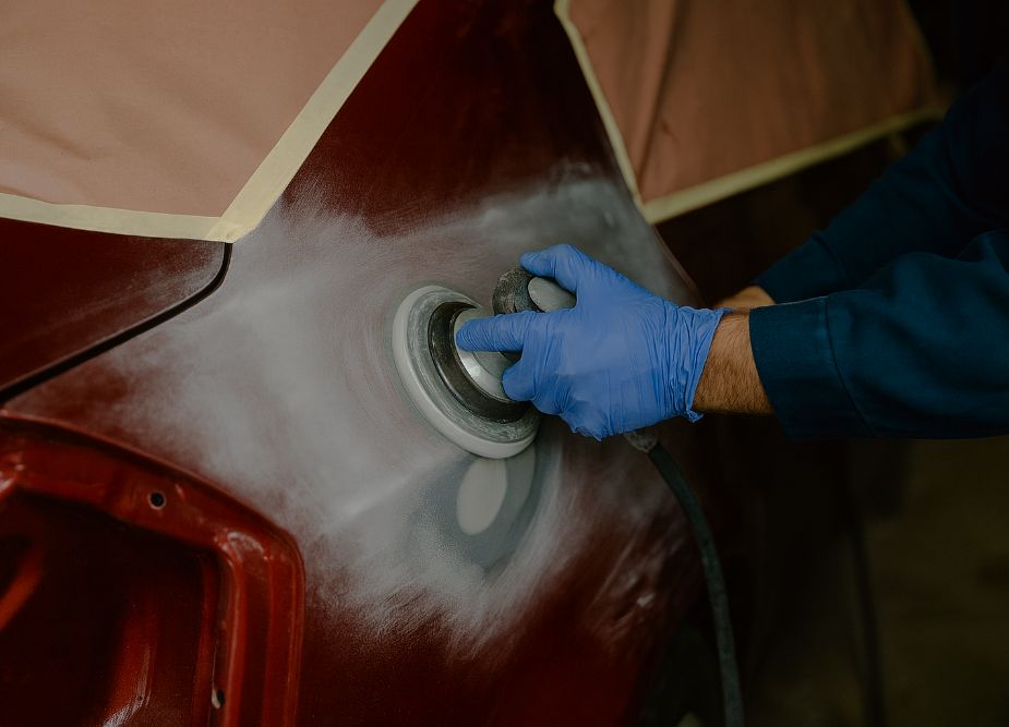 Technician sanding fender of red car for repair - collision repair services - california reflections auto body & paint